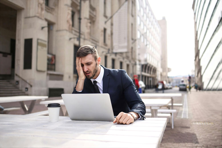 HR man in street on laptop finding it difficult, but not with Spencers recruitment
